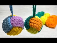 three crocheted balls are hanging from strings