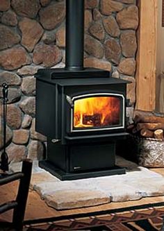 a wood burning stove sitting on top of a stone floor