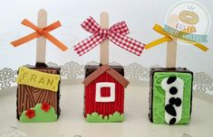 three little houses made to look like they are decorated with fondant and wooden sticks