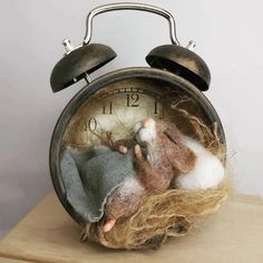 an old fashioned alarm clock with needle dolls in it