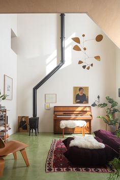 a living room filled with furniture and a piano in the middle of it's wall