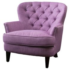 an upholstered purple chair with buttons on the armrests and back rests against a white background