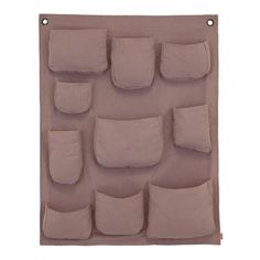 a pink wall hanging with several pockets and pillows on the bottom one pocket is filled with small, light - colored cushions