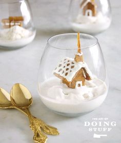 three gold spoons sitting on top of a table next to a glass filled with food