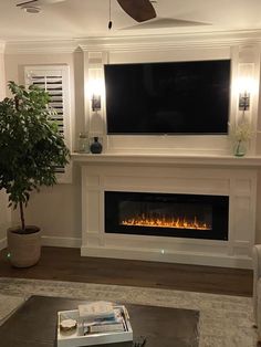 a living room filled with furniture and a flat screen tv mounted on the wall above a fire place