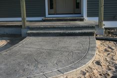 a house with steps leading up to the front door and side porch area in concrete