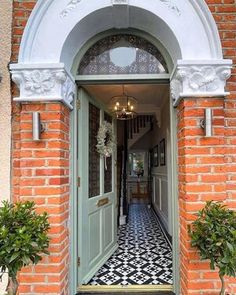 an entrance to a house with two potted plants