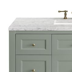 a bathroom vanity with marble counter top and gold faucet