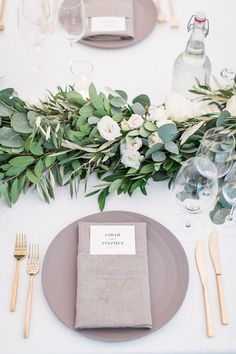 an image of a table setting with flowers and greenery on the place card holder