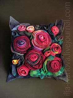 a decorative pillow made out of rolled up fabric with flowers on the front and back