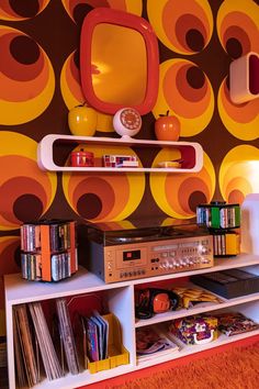 an orange and yellow wallpaper with various items on it in a living room area