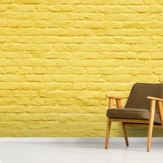 a chair against a yellow brick wall