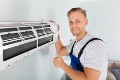 a man is holding an air conditioner in his hand