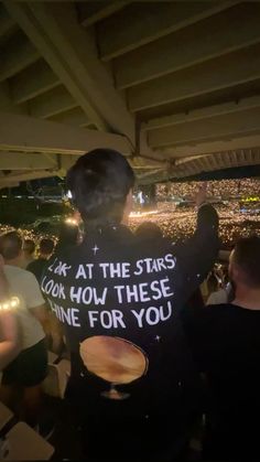 a man with a t - shirt that says look at the stars look how these shine for you