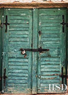 an old green door with two padlocks on it