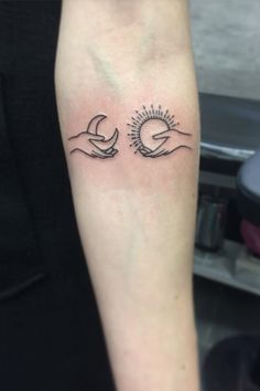 a woman's arm with two hands holding the sun and moon tattoo on it