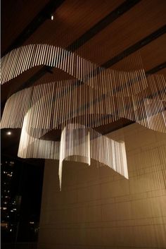 the lights are hanging from the ceiling in the building's lobby area, and it looks like they have been made out of wood