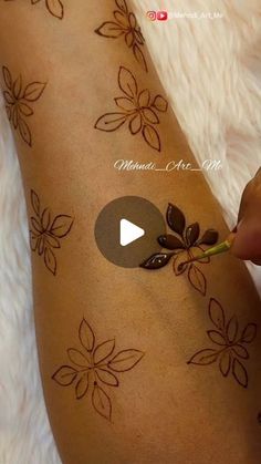 someone is doing something on their arm with flowers and leaves painted on it's side