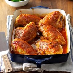 chicken legs covered in marinara sauce in a blue casserole dish