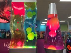 three colorful vases sitting on display in a store