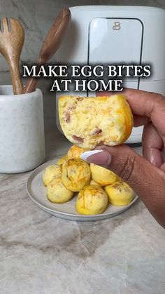 a person holding an egg in their hand with the words make egg bites at home