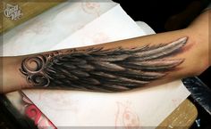 an arm with black and grey wings on it