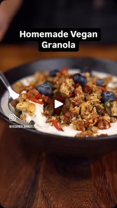 a bowl filled with granola on top of a wooden table