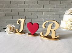 two wooden letters that spell out the word love with a red heart on each letter