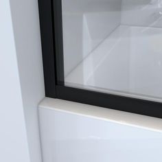 an empty white bathroom with black trim around the window