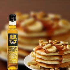 a stack of pancakes on a plate with syrup next to it and some sliced bananas