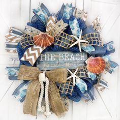 the beach wreath is made with burlocks and seashells, along with starfish