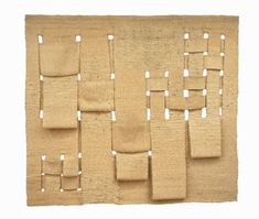 a beige rug with squares and rectangles on the bottom, in front of a white background