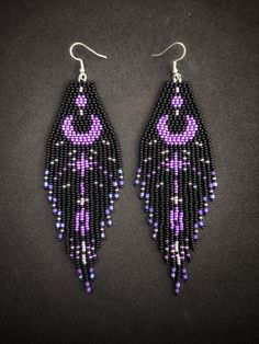 purple and black beaded earrings with an evil eye