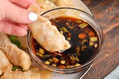 a person dipping some food into a small bowl