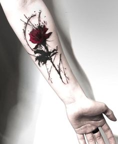 a woman's arm with a red rose tattoo on the left wrist and hand