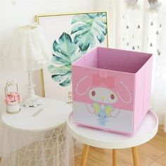 a pink and white box sitting on top of a wooden table next to a plant