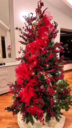 a christmas tree decorated with red ribbons and lights