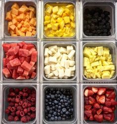 several trays filled with different types of fruits and vegetables in each one, including melon, pineapple, blueberries, raspberry, watermelon, kiwi