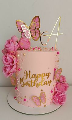 a pink birthday cake with gold butterflies and flowers