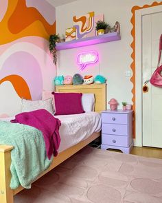 a bedroom decorated in pink, green and yellow