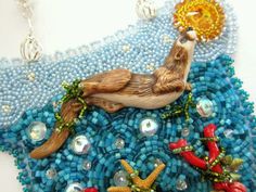 a beaded necklace with an image of a sea animal and other items on it