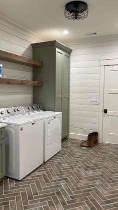 a washer and dryer sitting in a laundry room next to a dog laying on the floor