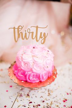 a pink and gold birthday cake with the word thirty on top