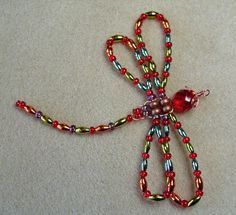 a beaded dragon brooch sitting on top of a table