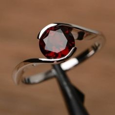 a close up of a ring with a red stone