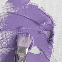 a purple paintbrush is sitting on top of a white background with some brush in it's left hand