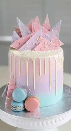 a pink and blue cake with icing on top