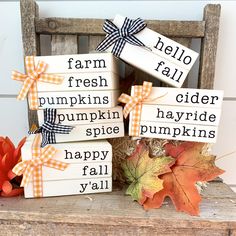 three wooden blocks with words on them sitting in front of fall leaves and pumpkins