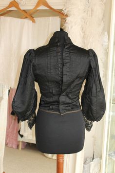 Edwardian fitted black satin blouse with lace and buttons, Pigeon front antique blouse, Gothic/Steampunk/theatre costume, ladies bodice top. Genuine late Victorian/early Edwardian fitted black satin blouse with lace and buttons. Amazing condition for it's age, this lovely soft satin ladies  blouse has a small stand up collar covered in corded lace which also forms the centre front V just below the neck. Either side of the lace panel are 3 pleats which are sewn down from the shoulder to the bust Elegant Corset With Historical Design For Costume Party, Elegant Historical Design Corset For Costume Party, Long Sleeve Gothic Blouse For Formal Occasions, Formal Gothic Long Sleeve Blouse, Fitted Lace Trim Corset For Evening, Gothic Long Sleeve Blouse For Evening, Gothic Black Top With Lace Collar, Elegant Black Corset With Lace Trim, Gothic Blouse For Evening In Fall