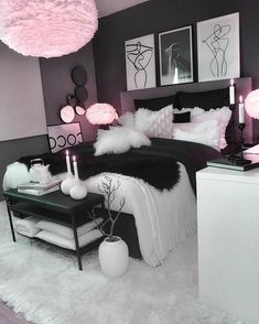 a bedroom decorated in black and white with pictures on the wall